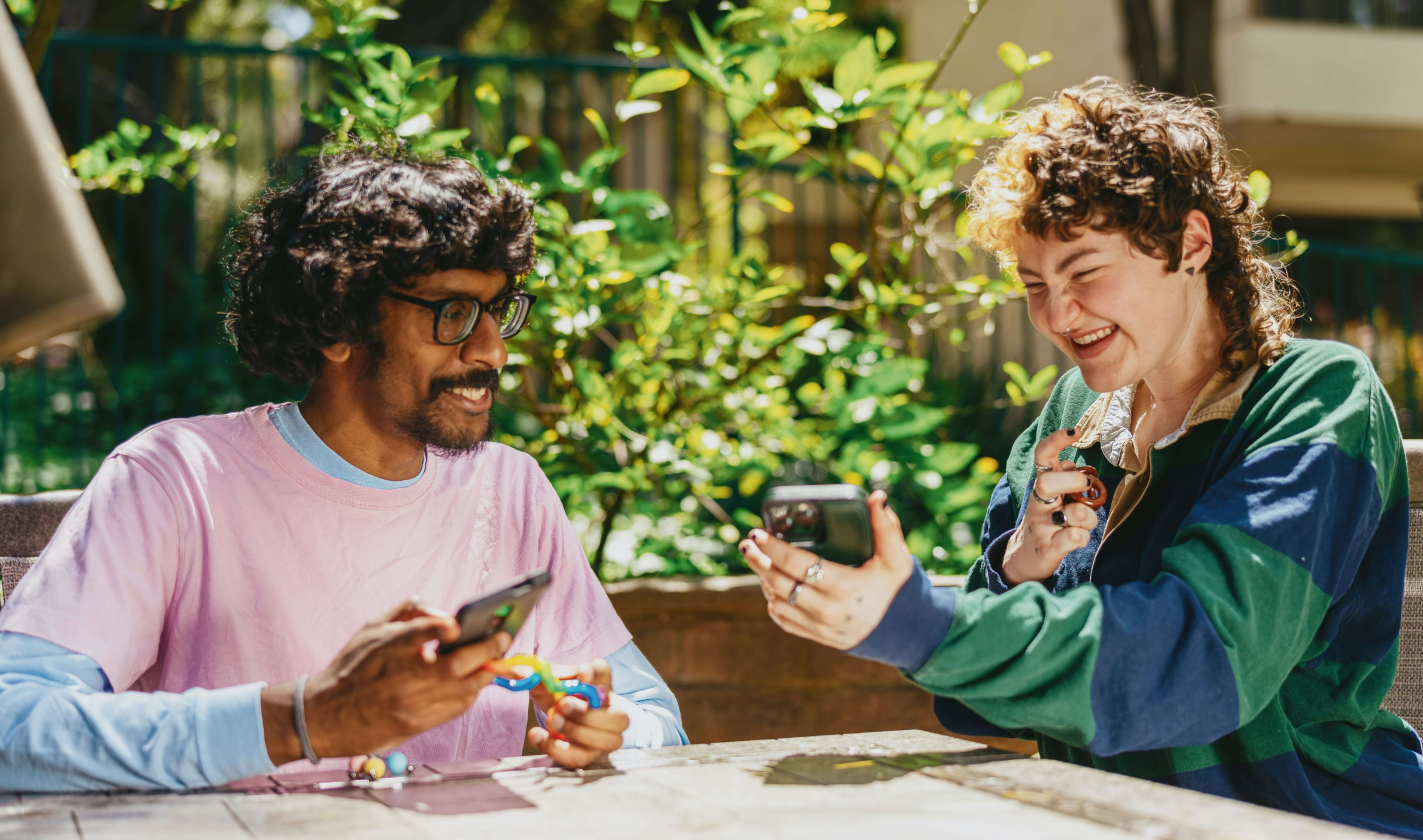 Two people meeting outdoors sharing content on their cell phones